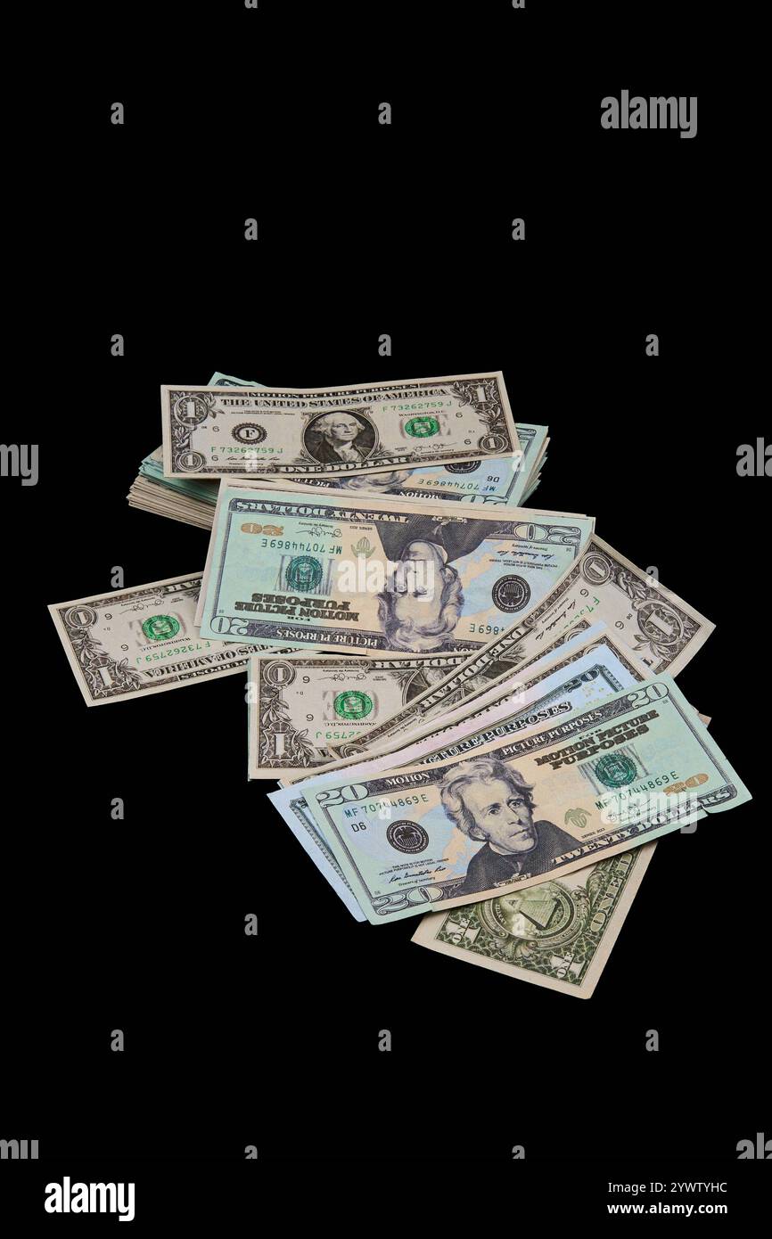 Auf einer dunklen Oberfläche befindet sich ein Stapel Bargeld, auf dem verschiedene Banknoten ausgestellt sind. Das Geld beinhaltet Dollar, was Spareinlagen und Währung in Rechteck darstellt Stockfoto