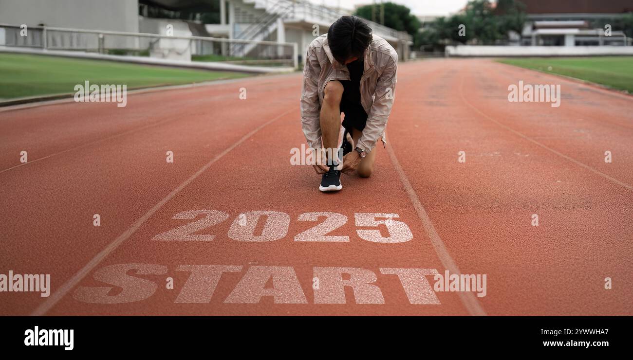 Läufer, der sich auf ein Rennen auf der Strecke vorbereitet, mit der Startlinie 2025, die neue Anfänge und zukünftige Ziele bei Sport und persönlichen Erfolgen symbolisiert Stockfoto