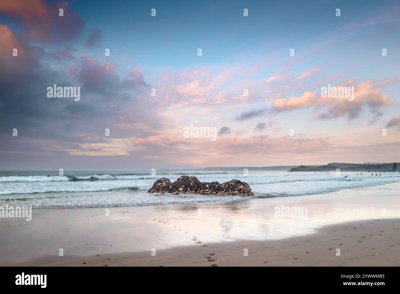 Pastellfarbener Himmel über Felsen, die von Ebbe am GT Western Beach an der Küste von Newquay in Cornwall in Großbritannien freigelegt werden. Stockfoto