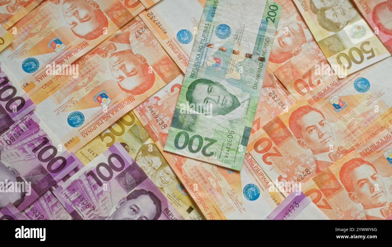 Philippinische Banknoten in Stückelungen von 20, 50, 100 und 200 Pesos auf einer flachen Oberfläche mit verschiedenen Helden und historischen Symbolen. Stockfoto