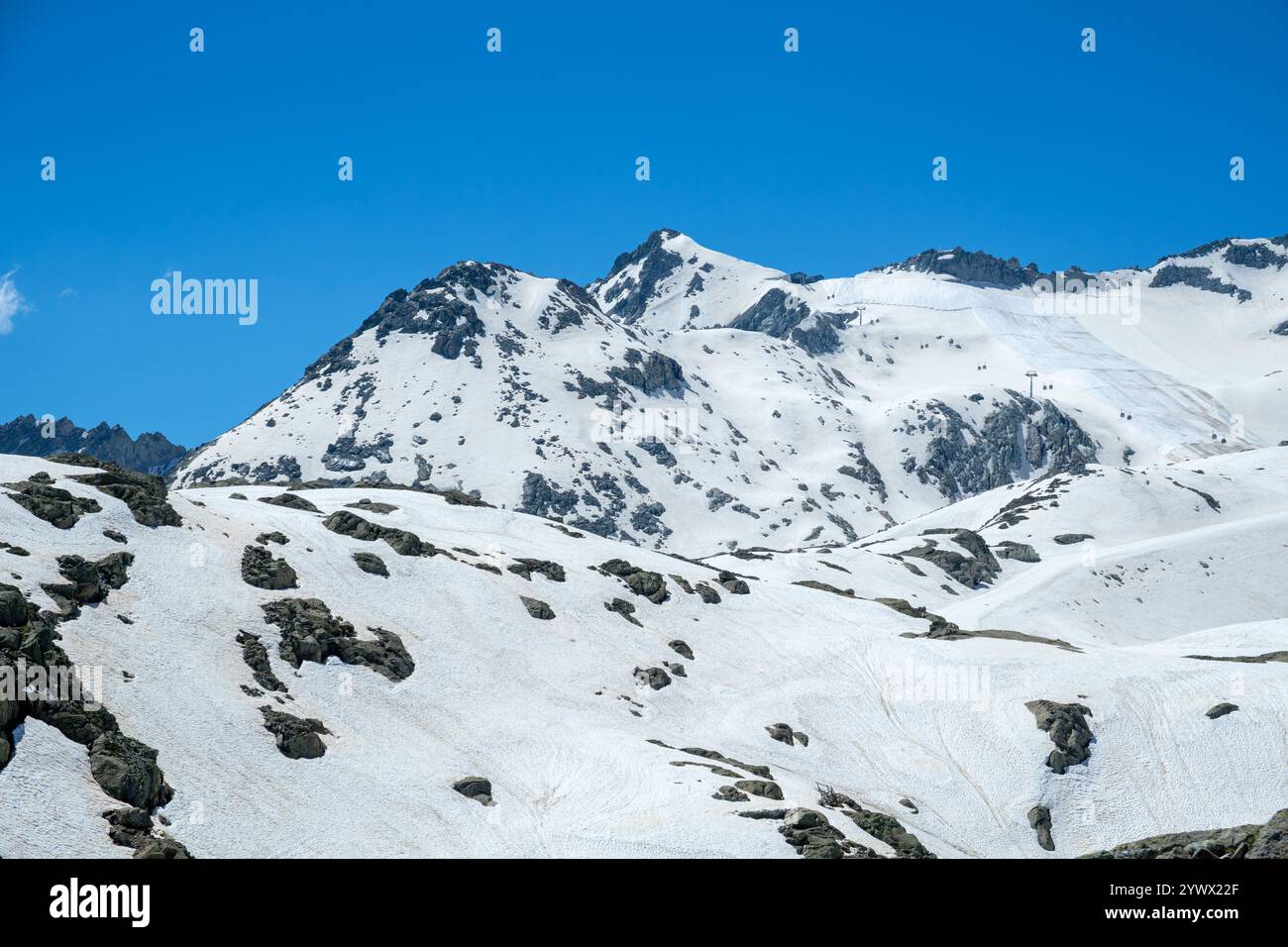 Skipisten und majestätische schneebedeckte Berge dominieren die Landschaft in Vermiglio, Italien, unter einem hellblauen Himmel. Die ruhige Umgebung lädt im Freien ein Stockfoto