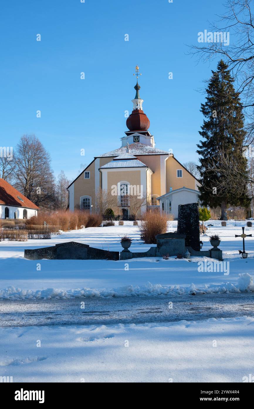 Leksand, Dalarna, zeigt eine bezaubernde Kirche, die im Winter von Schnee umgeben ist. Der klare blaue Himmel steht in wunderschönem Kontrast zur weißen Landschaft, Providi Stockfoto