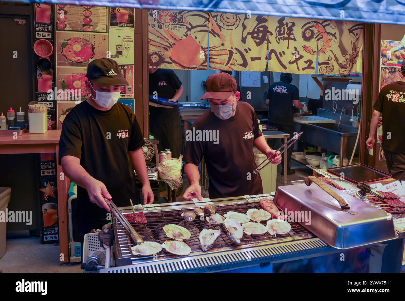 Männer bereiten Meeresfrüchte in einem Restaurant am Straßenrand in der Outer Tsukiji Market Area, Tsukiji, Chuo City, Tokio, Japan, Asien zu. Stockfoto