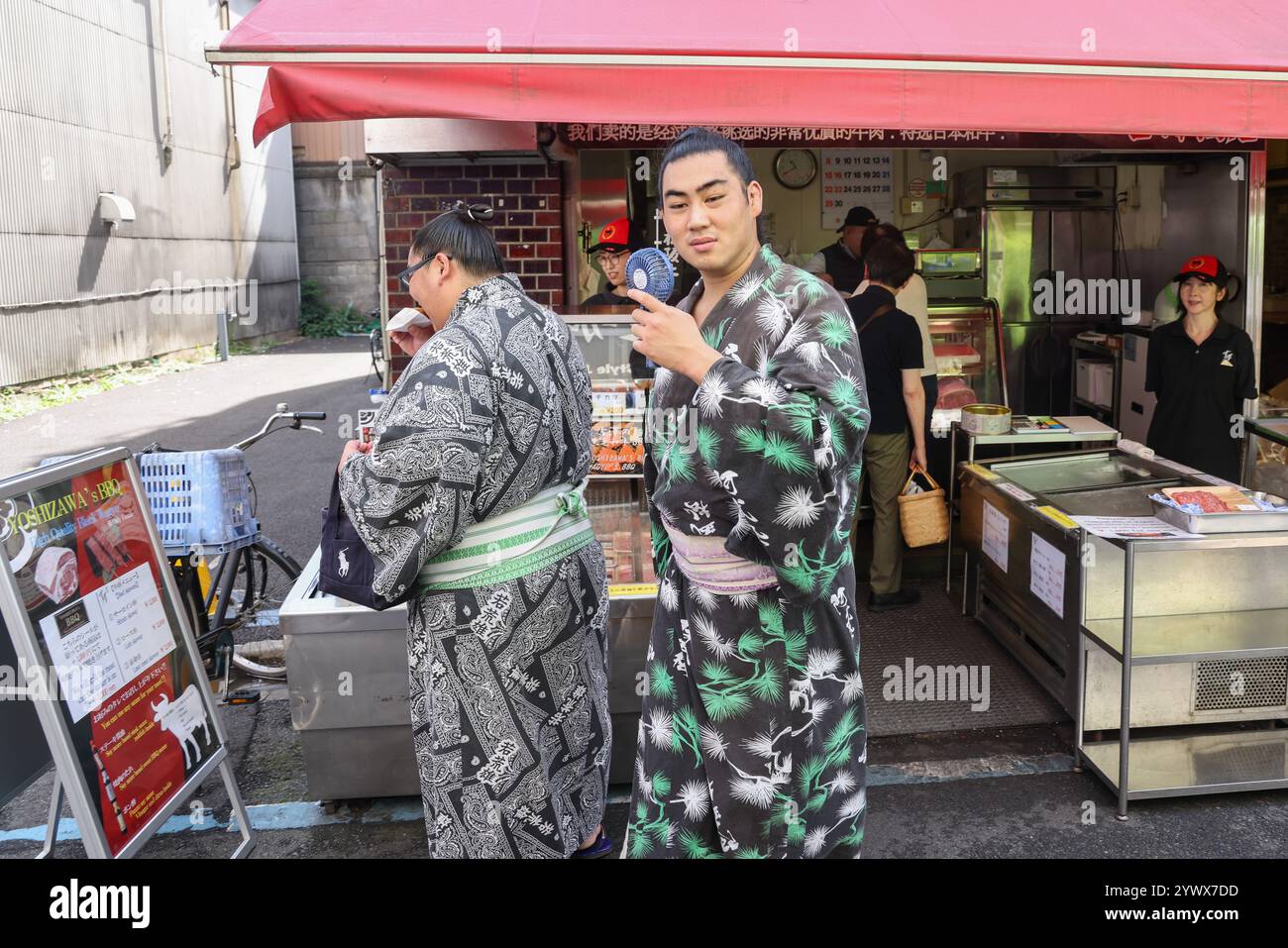 Zwei Sumo-Wrestler an einem Street-Food-Stand auf dem Tsukiji Outer Market in Tokio, Chuo City, Japan, Asien. Stockfoto
