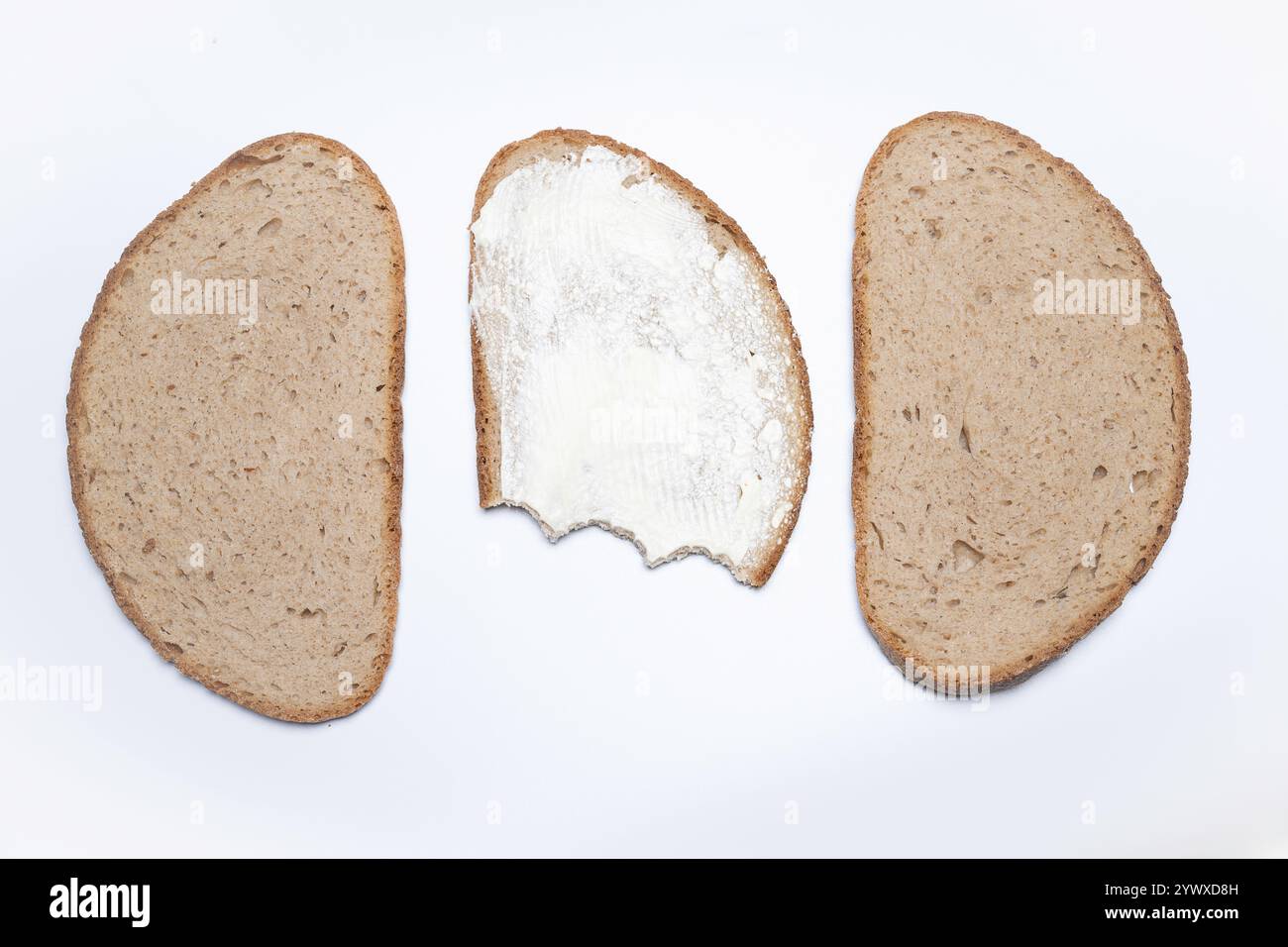 , Deutschland, 12.12.2024, drei Brotscheiben, eine davon mit Butter und angebissen, auf weißem Hintergrund. Ideal für gesunde Snacks und Ernährungsin Stockfoto