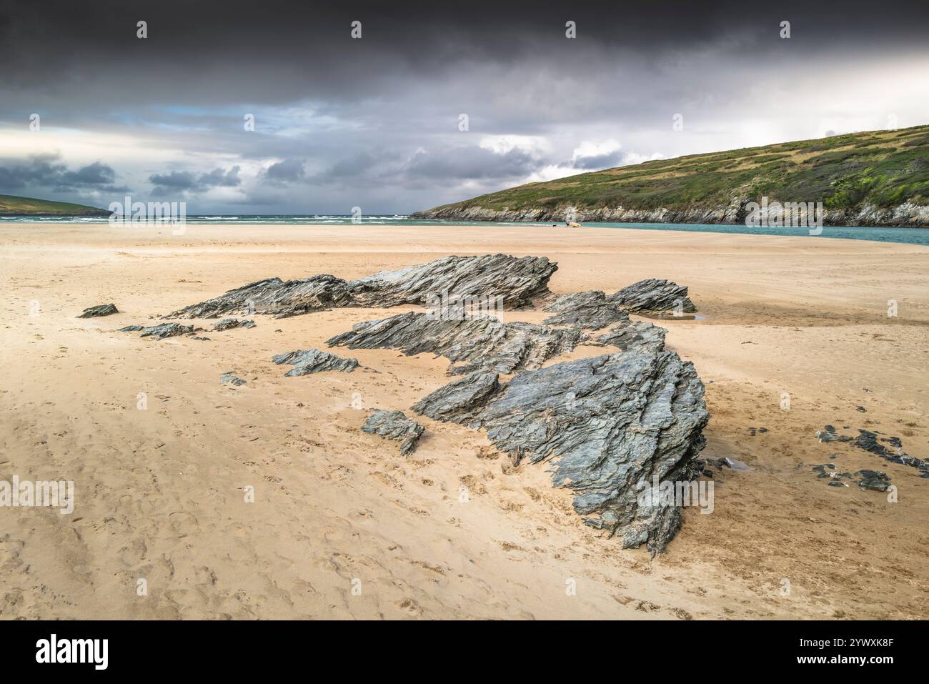 Felsen, die von den starken Gezeiten am Crantock Beach in Newquay in Cornwall in Großbritannien freigelegt werden. Stockfoto Felsen, die von den starken Gezeiten am Crantock Beach in Newquay in Cornwall in Großbritannien freigelegt werden. Stockfoto