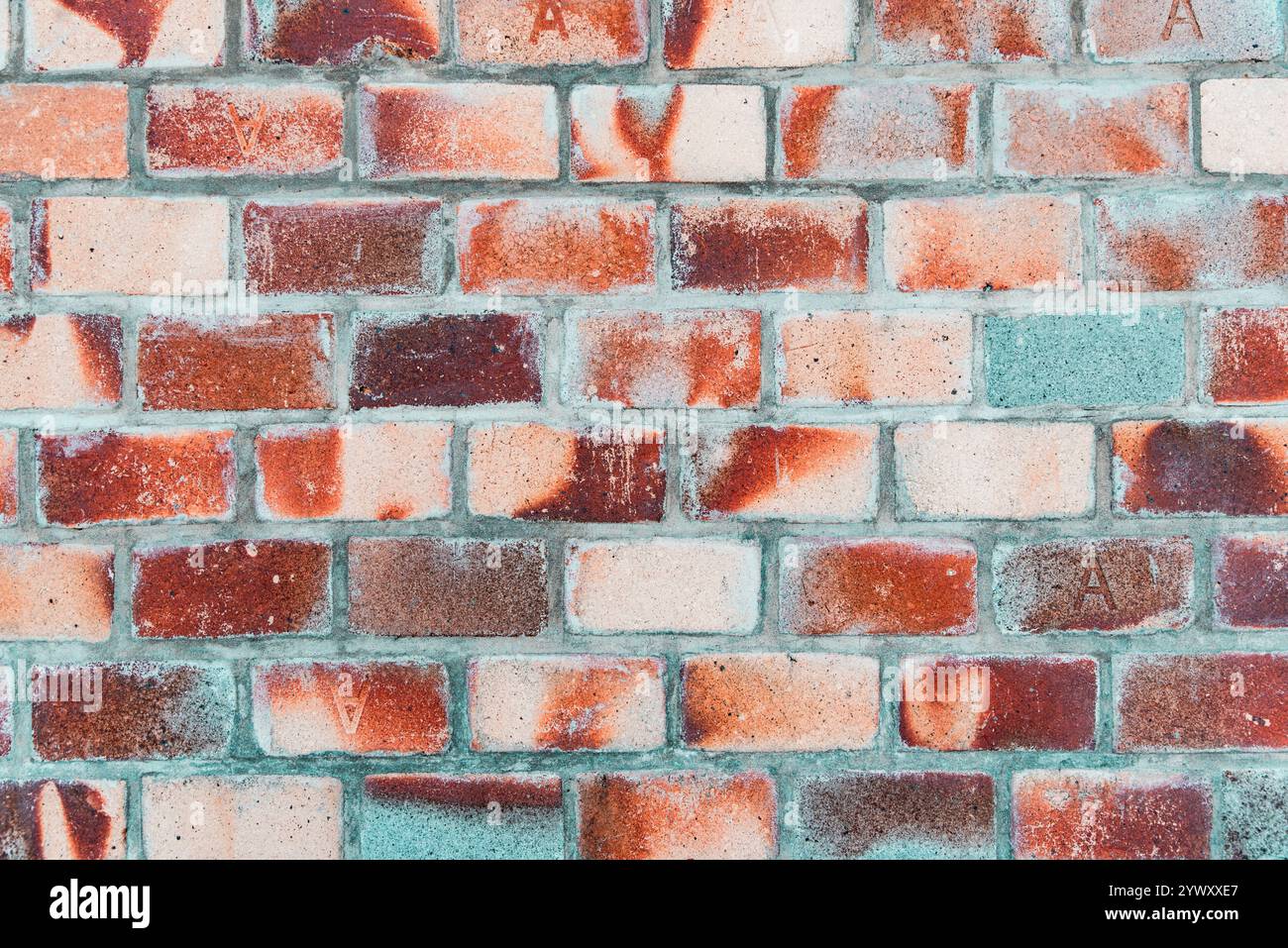 Eine Ziegelmauer mit einem grünen und roten Streifen. Die Wand ist aus Ziegeln Stockfoto