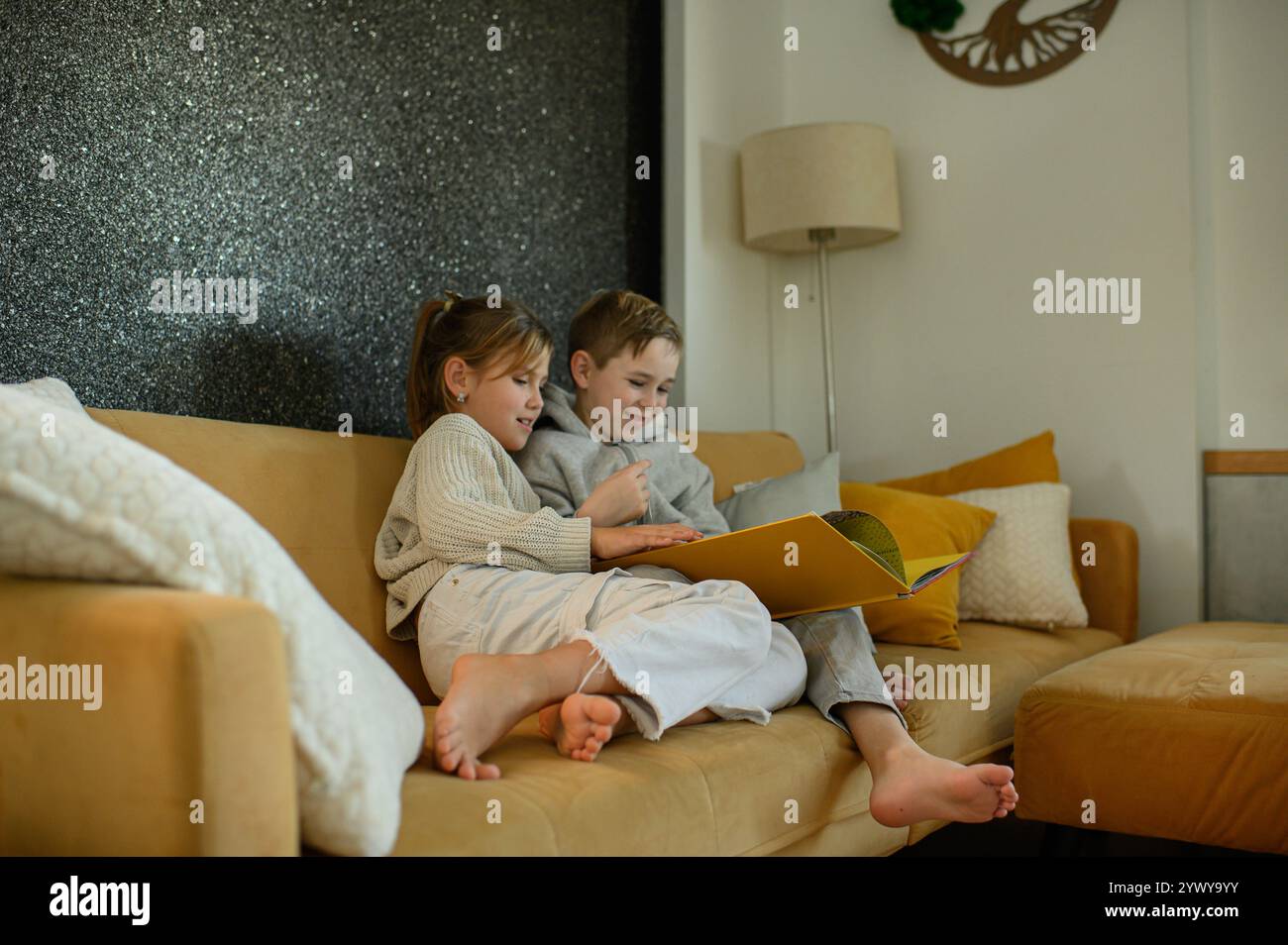 Junge und Mädchen lesen zu Hause Bücher auf dem Sofa Stockfoto