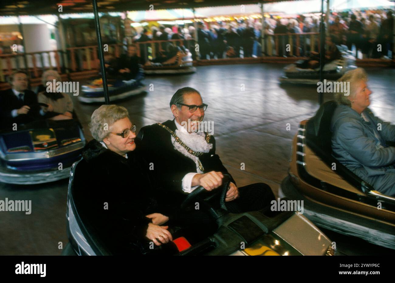 Die Nottingham Goose Fair, der Lord Mayor of Nottingham und seine Frau, die Lady Mayoress, machen eine Fahrt mit den Dodgem Cars bei der Eröffnung dieses jährlichen Jahrmarktes. Forest Recreation Ground in Nottingham Nottingham, Nottinghamshire, England um den 1985 1980. Oktober. Stockfoto