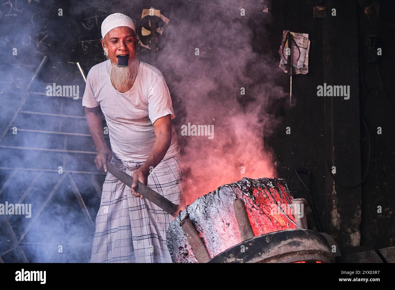 In einer Werft in Bangladesch beschäftigt sich ein erfahrener Handwerker mit umfangreicher Erfahrung geschickt mit der Herstellung von Schiffspropellern. Seine erfahrenen Hände klagen Stockfoto
