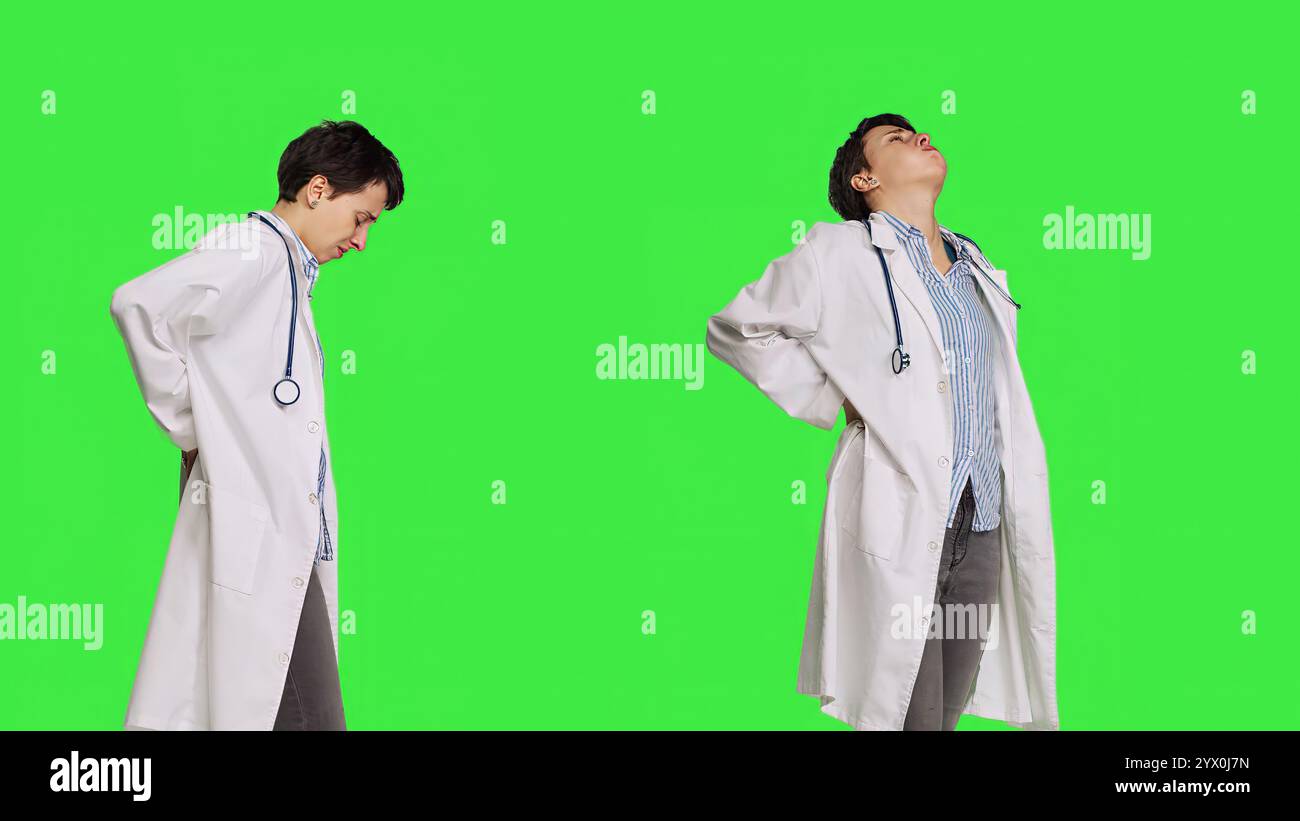 Ärztin mit akuten Schmerzen im unteren Rücken im Studio, Skoliose und Muskelbeschwerden. Der Arzt kümmert sich um Rückenschmerzen von Burnout, Greenscreen Hintergrund. Kamera B.. Stockfoto