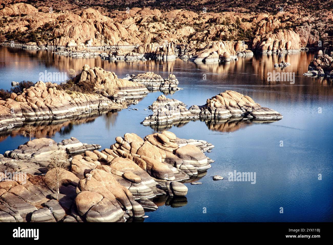 Die markanten Felsformationen der Granite Dells, die sich vor dem ruhigen Wasser des Watson Lake befinden, bilden eine atemberaubende Landschaft in Prescott, Arizona. Stockfoto