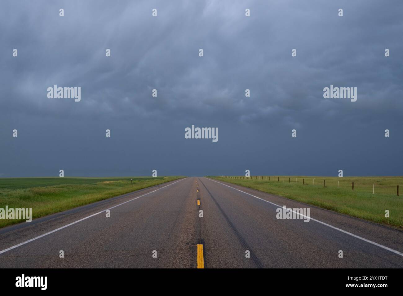 Landschaftsblick auf einen einsamen Highway mit einem schweren Sturm am Horizont auf den Hochebenen von South Dakota Stockfoto