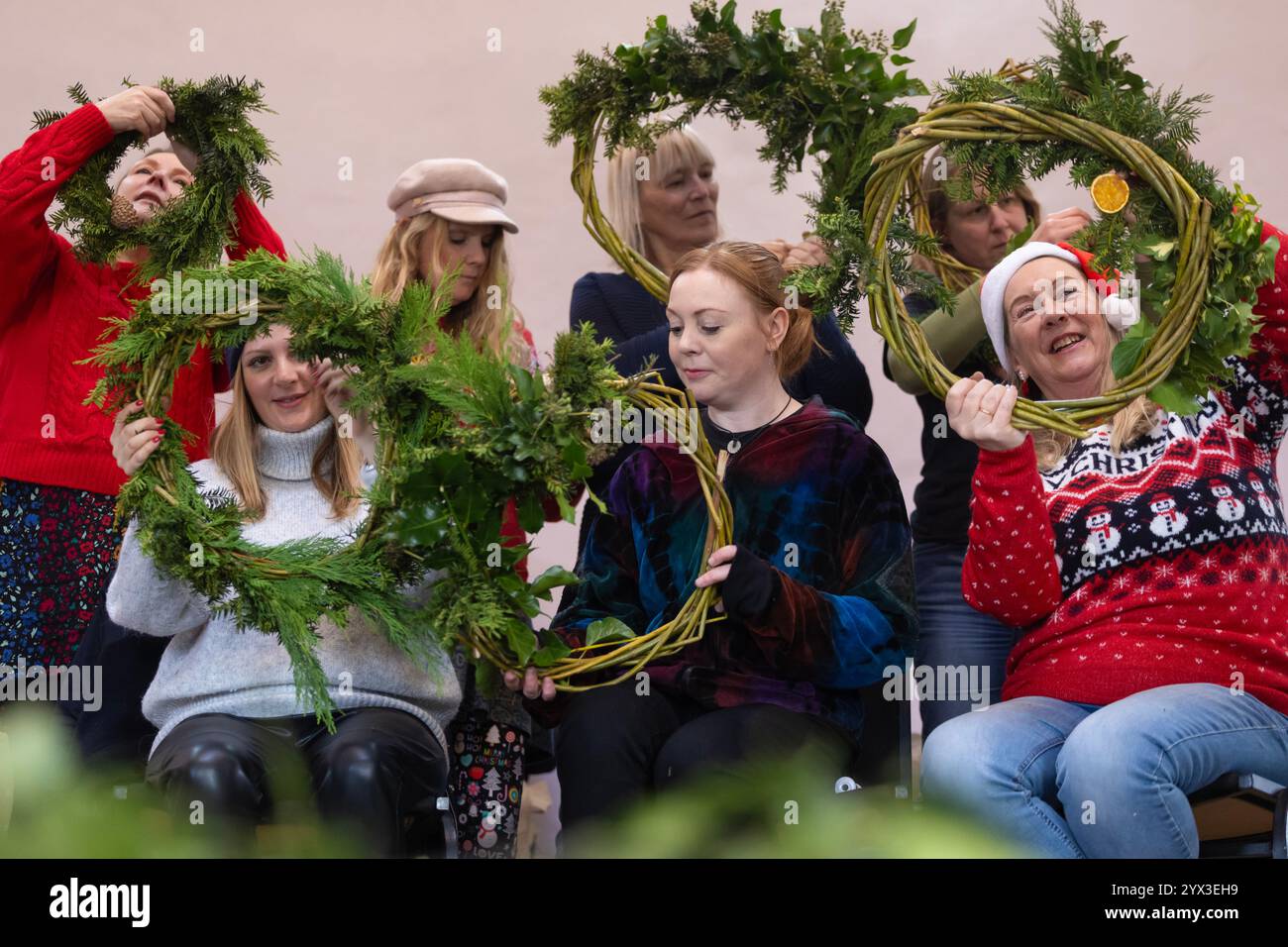 12/24 Eine Gruppe von Damen lernt, Weihnachtskränze in einer Werkstatt im Whistlewood Common, Melbourne Derbyshire zu machen. Die festliche Dekoration Stockfoto