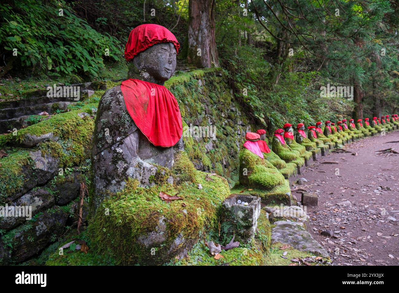 Horizontales Bild von buddha-Statuen bedeckt mit grünem Moos. Stockfoto