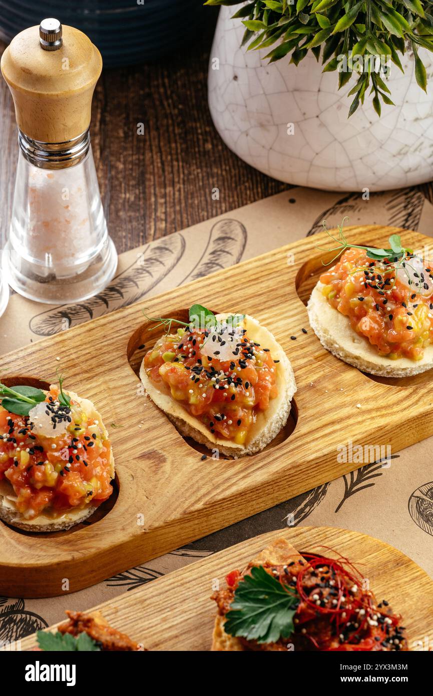 Bruschetta mit Lachstartar auf einem Servierbrett Stockfoto
