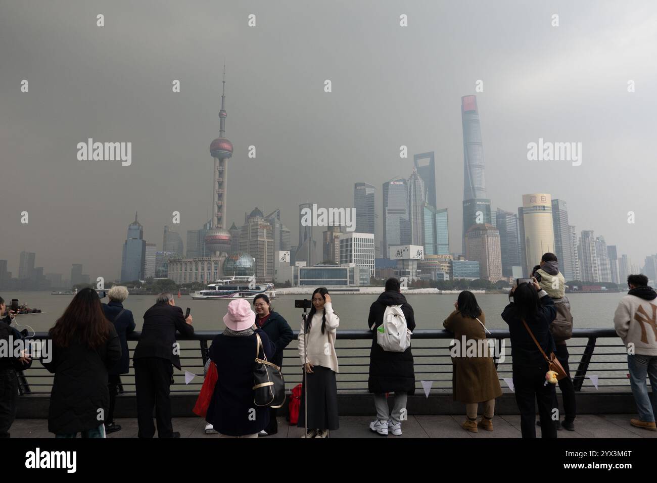 Chinesische und ausländische Touristen genießen den wunderschönen Blick auf die Hochhäuser von Lujiazui auf der anderen Seite des Huangpu-Flusses in der Nähe der Landschaftsplattform Bund in Stockfoto