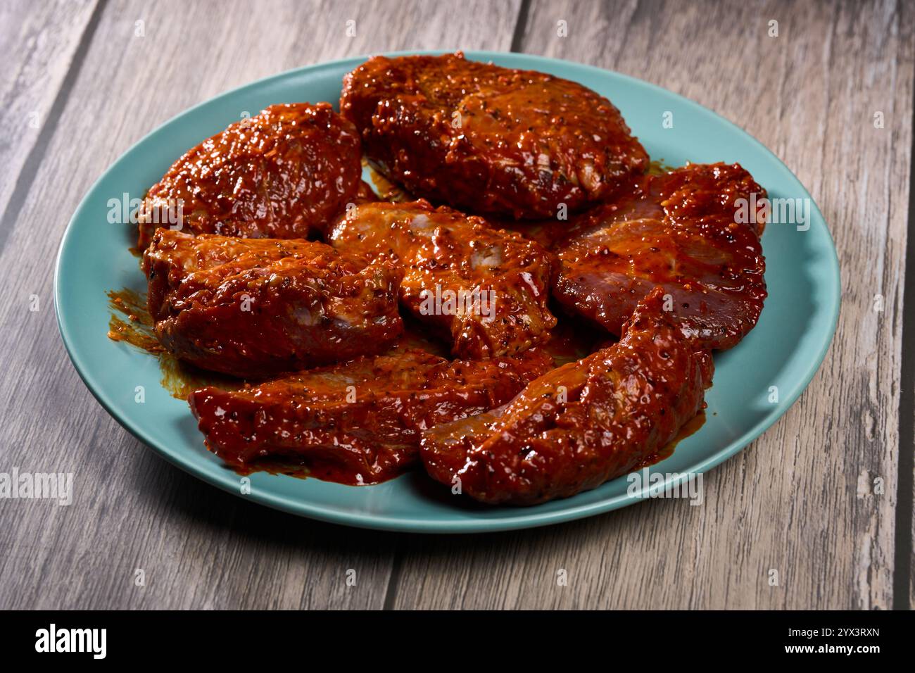 Marinierte Schweinebacken (Wangen) Filets auf einem Holzbrett in der Nähe Stockfoto