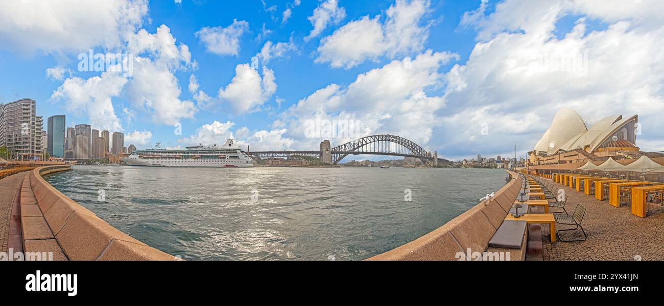 Panoramablick auf den Hafen von Sydney mit Opernhaus, Harbour Bridge und Kreuzfahrtschiff unter dramatischen Wolken während des Tages Stockfoto