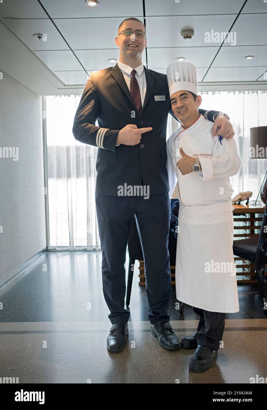 Auf einem Viking Kreuzfahrtschiff der 6 Fuß 7 Hotel Manager wirft mit der 5 Fuß 2 Chefkoch. Auf der Donau Kreuzfahrt. Stockfoto