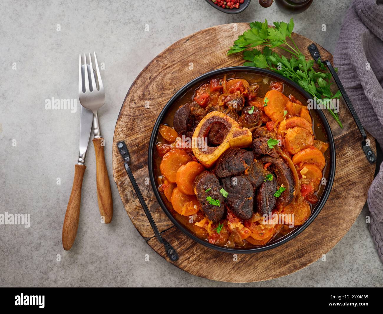 Ossobuco. Steak Kalbsbacken oder Eintopf mit Gemüsesauce und Gewürzen auf einem alten Betontisch Hintergrund. Italienische Küche Hintergrund mit Zutaten. Stockfoto