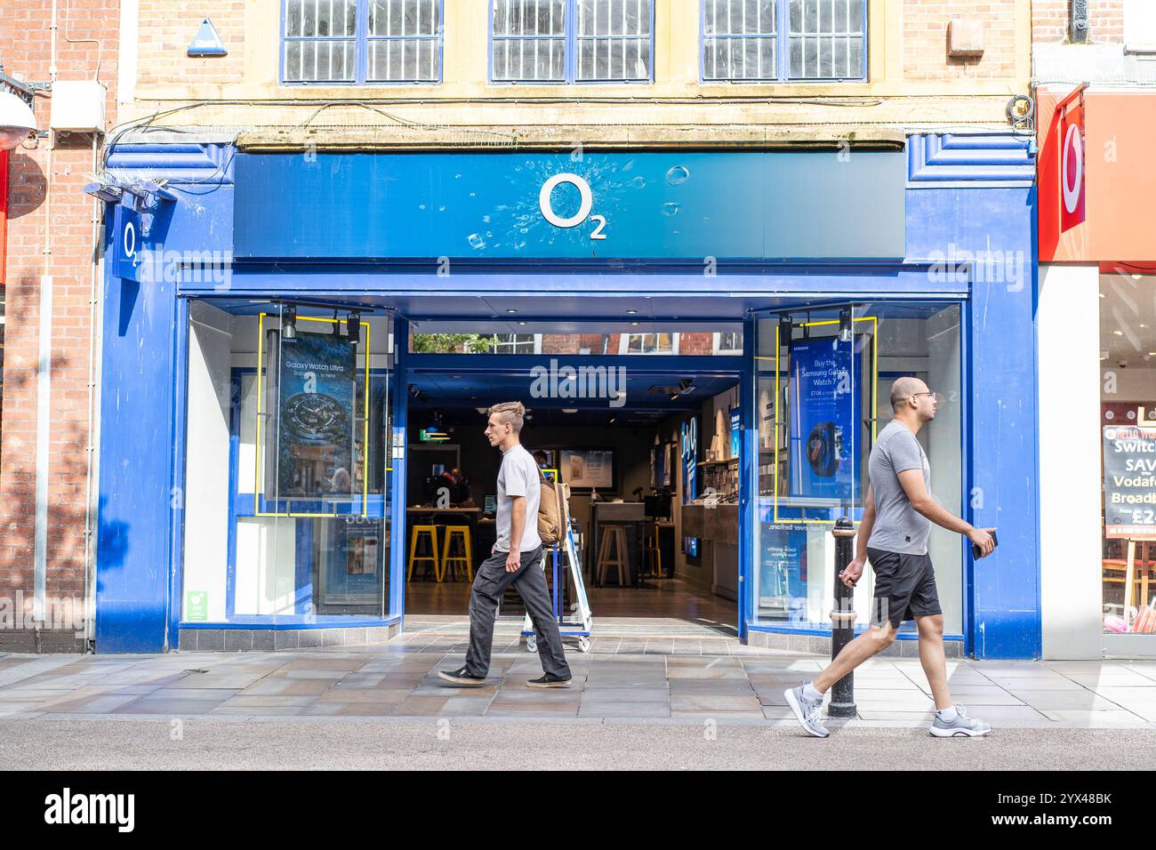 Nahaufnahme eines O2-Geschäfts in einer Hauptstraße mit Leuten vor dem Geschäft. Stockfoto