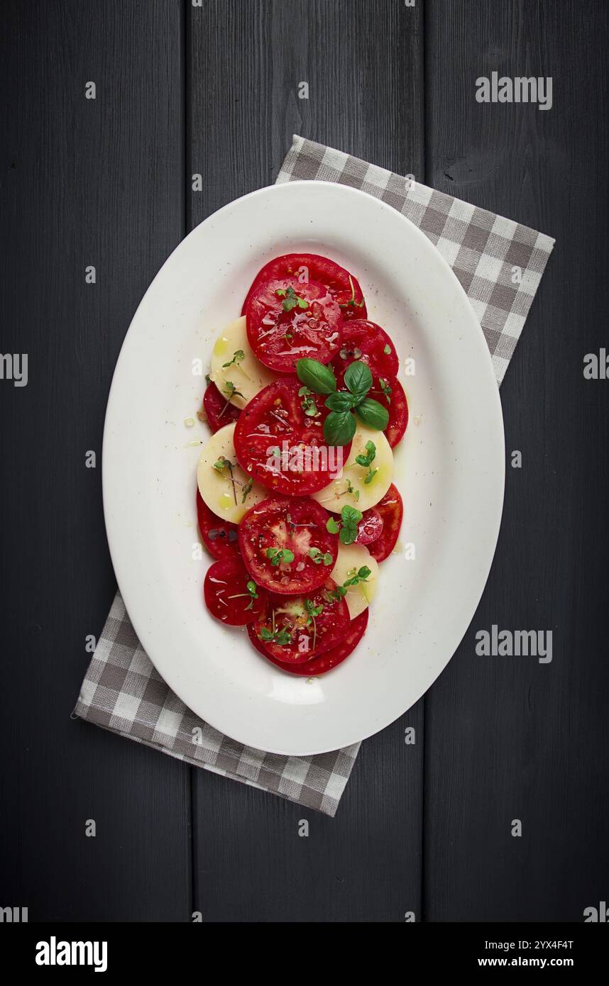 Caprese Salat, traditionelles italienisches Gericht, Tomaten mit Mozzarella Käse, Basilikum und Gewürzen, Blick von oben, keine Leute Stockfoto