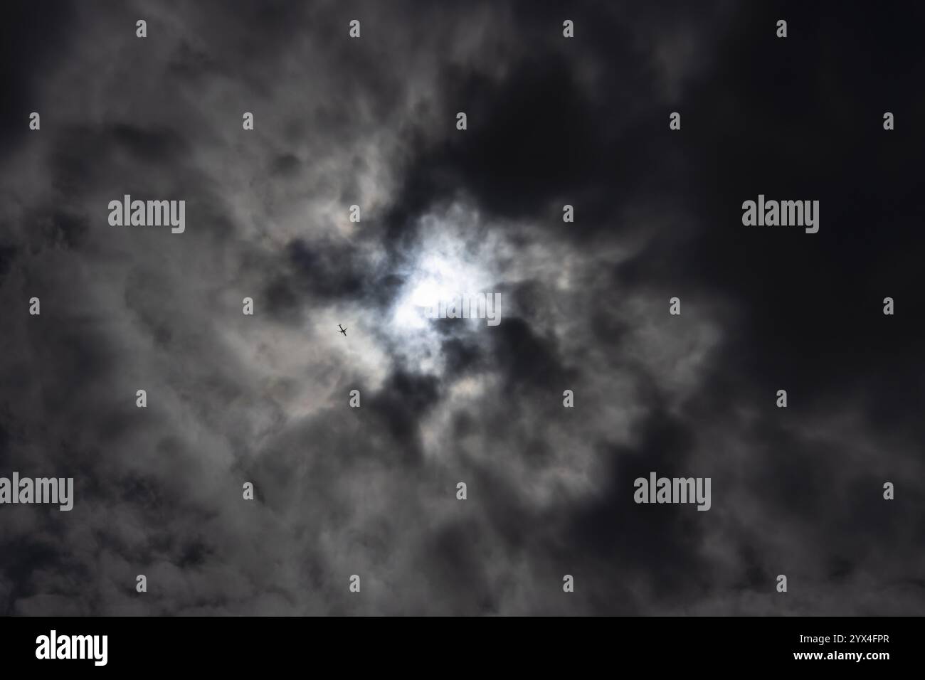 Nimbostratus dunkle Wolken am Himmel mit einem Flugzeugflugzeug, das darunter fliegt, England, Großbritannien, Europa Stockfoto