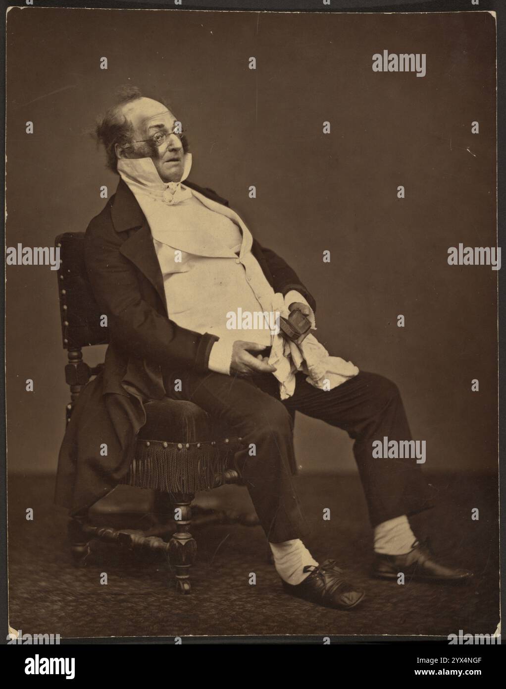 Henri Monnier, etwa 1875. Porträt eines übergewichtigen Mannes, der eine weiße Weste mit hohem Kragen unter einer dunklen Jacke trägt, auf einem Stuhl sitzt und eine Schnupfbox hält. Stockfoto