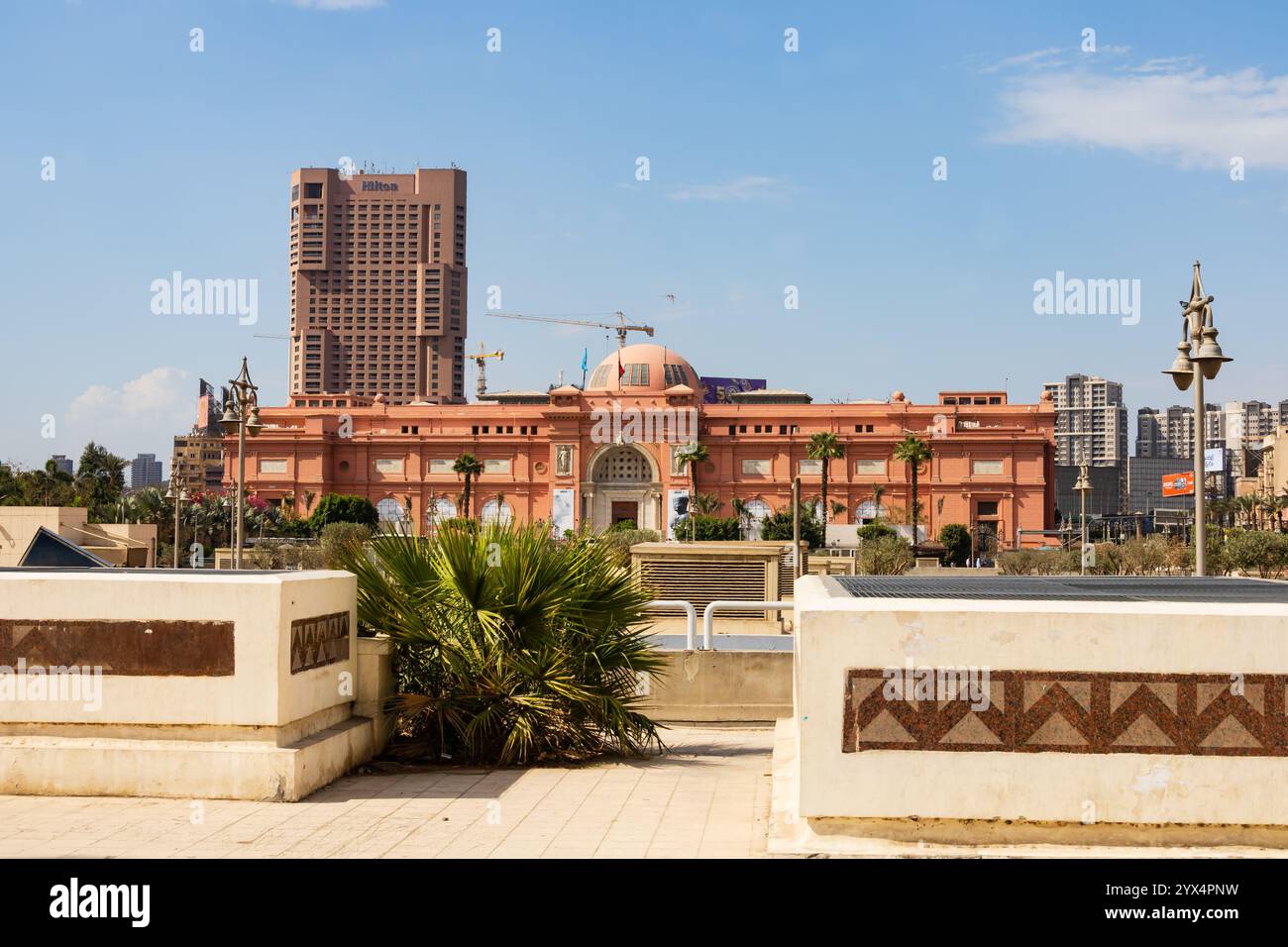 Das rosafarbene Gebäude des Cairo Museum of Antiquities, Tahrir Square, mit Cairo Hilton Hotel. Kairo, Ägypten Stockfoto