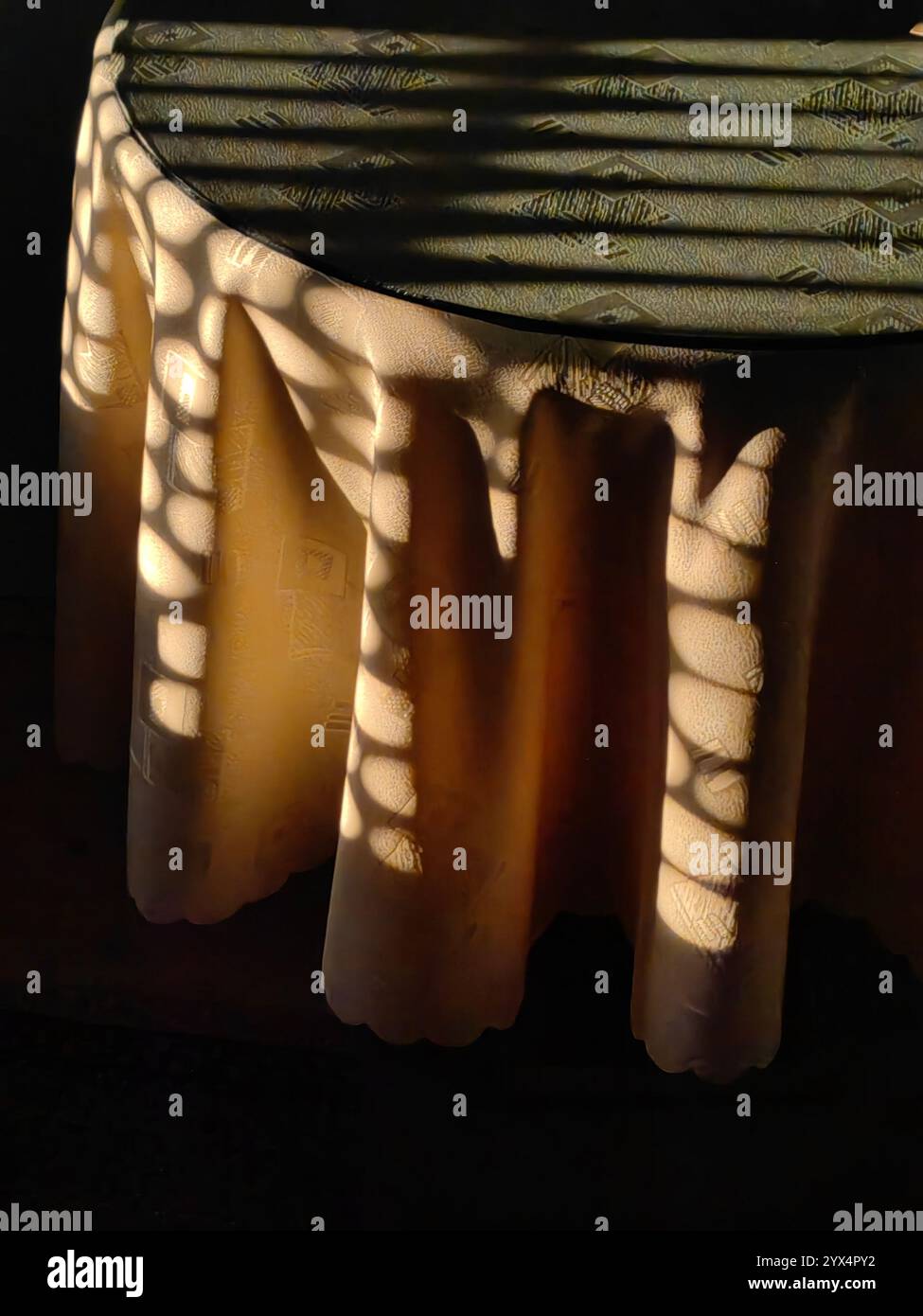 Sonnenuntergangsbeleuchtung: Gelbe Tischplatte und Glasharmonie. Stockfoto