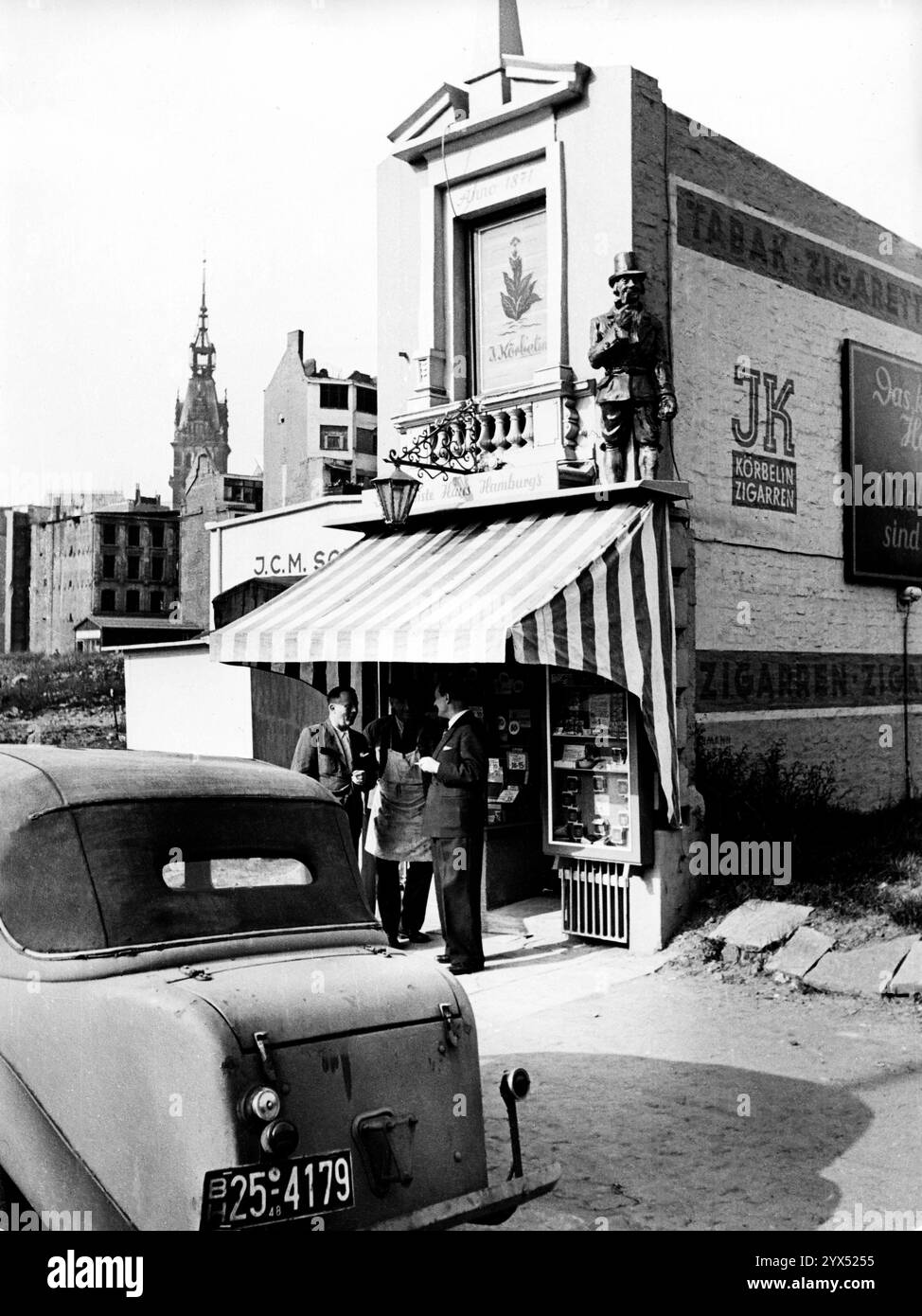 Männer stehen vor der Ausstellung von Zigarren Körbelin, der seine Waren im kleinsten Haus Hamburgs verkauft. [Automatisierte Übersetzung] Stockfoto