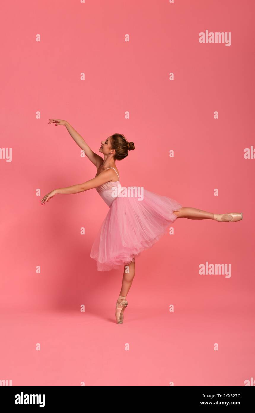 Ballerina in einem pinkfarbenen Tutu mit klassischer Pose auf pointe. Konzept: anmut, weiblichkeit und Eleganz im Ballett Stockfoto