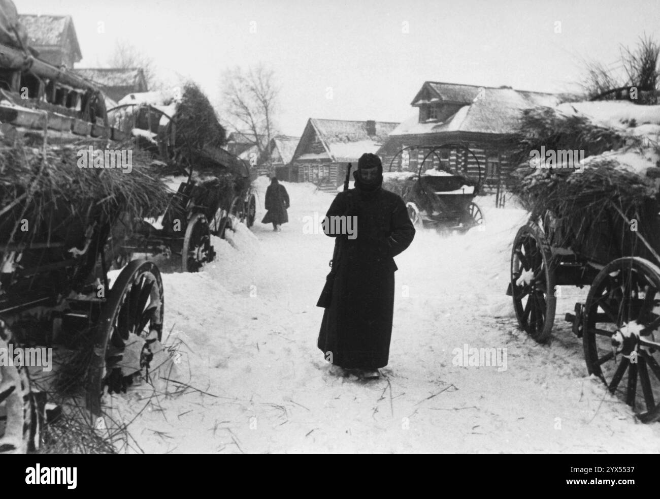 Soldaten und Wagen mit Stroh in Pelenichino bei Temperaturen von 30 Grad unter Null im März 1942. Die Wachen, die rund um die Uhr wachsam sein mussten, hatten spezielle Mäntel und Überschuhe, um die extreme Kälte zu bekämpfen. [Automatisierte Übersetzung] Stockfoto