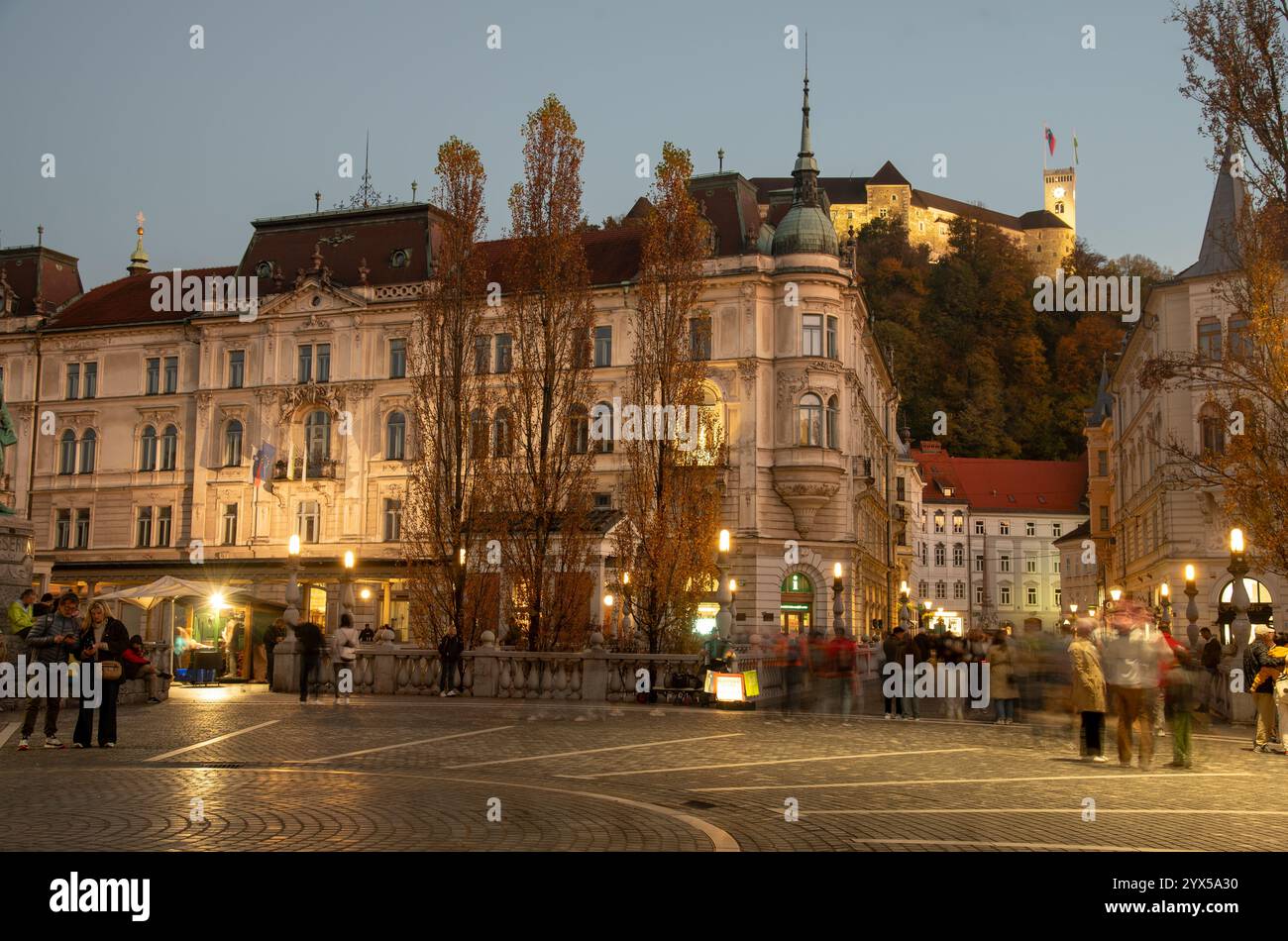 Ljubljana, Slowenien, Oktober 30 2024: Die Menschen genießen die abendliche Atmosphäre auf dem preseren Platz mit der Burg ljubljana und den Herbstbäumen im Hintergrund Stockfoto