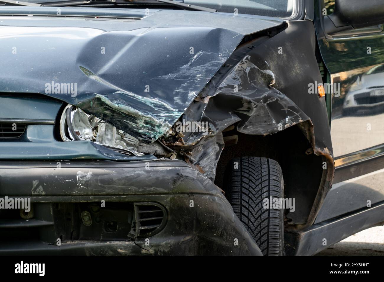 Zur Detaildarstellung von gebrochenem Scheinwerfer und Stoßfänger bei Dunkelwagen nach Verkehrsunfall Stockfoto