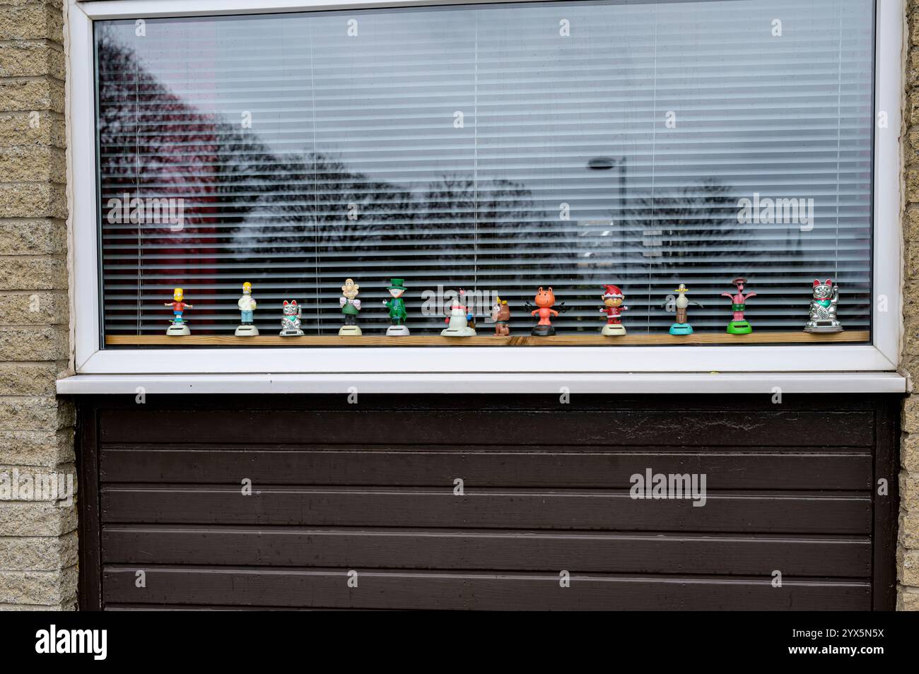 Nickende Figuren auf der Innenseite eines Hausfensters, Großbritannien Stockfoto