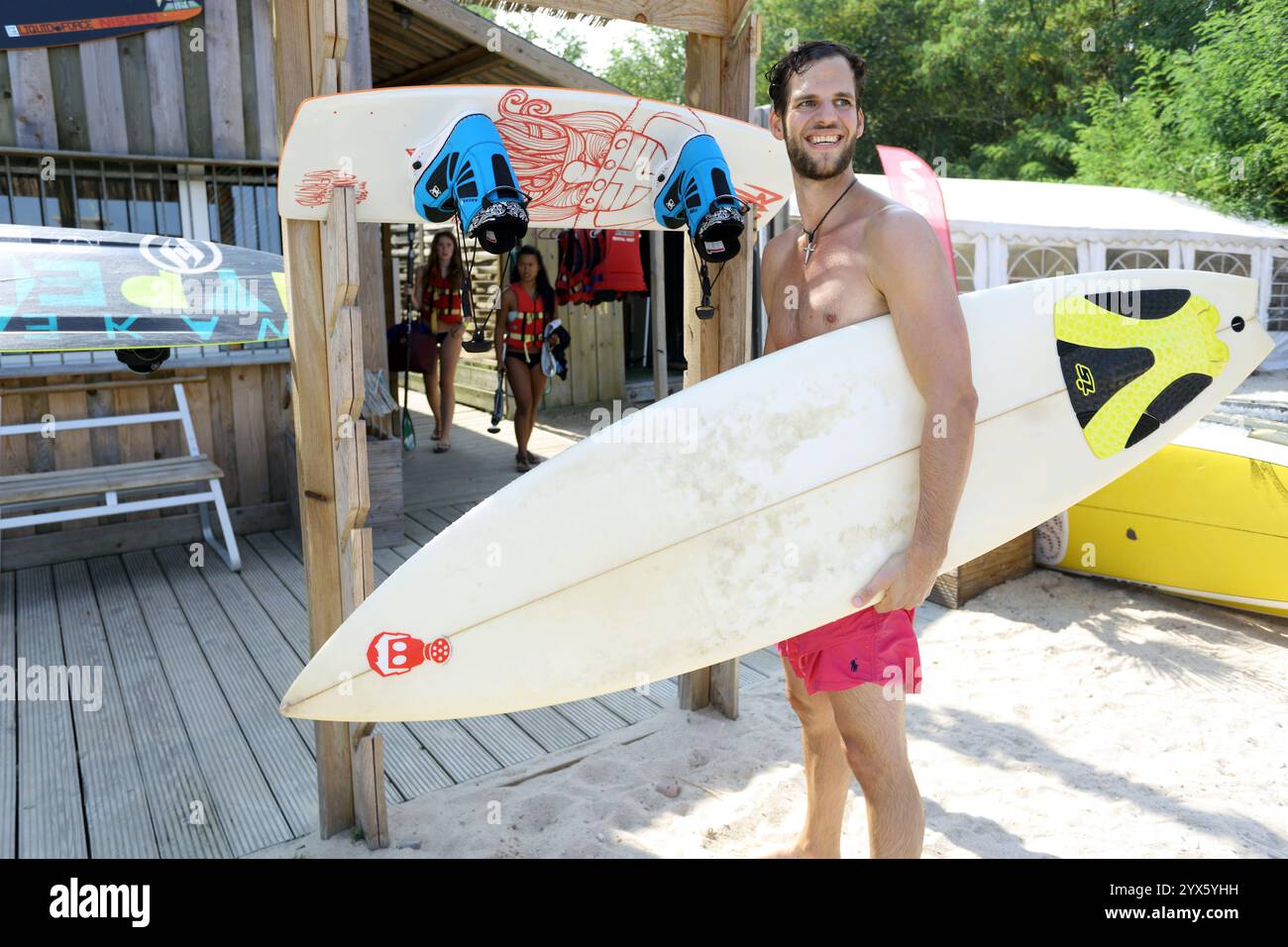 Männliche Surfer genießen Sommersonne an einem kleinen Strand am Wakeport Rhein Main bei Raunheim, Hessen, Deutschland, Europa Stockfoto