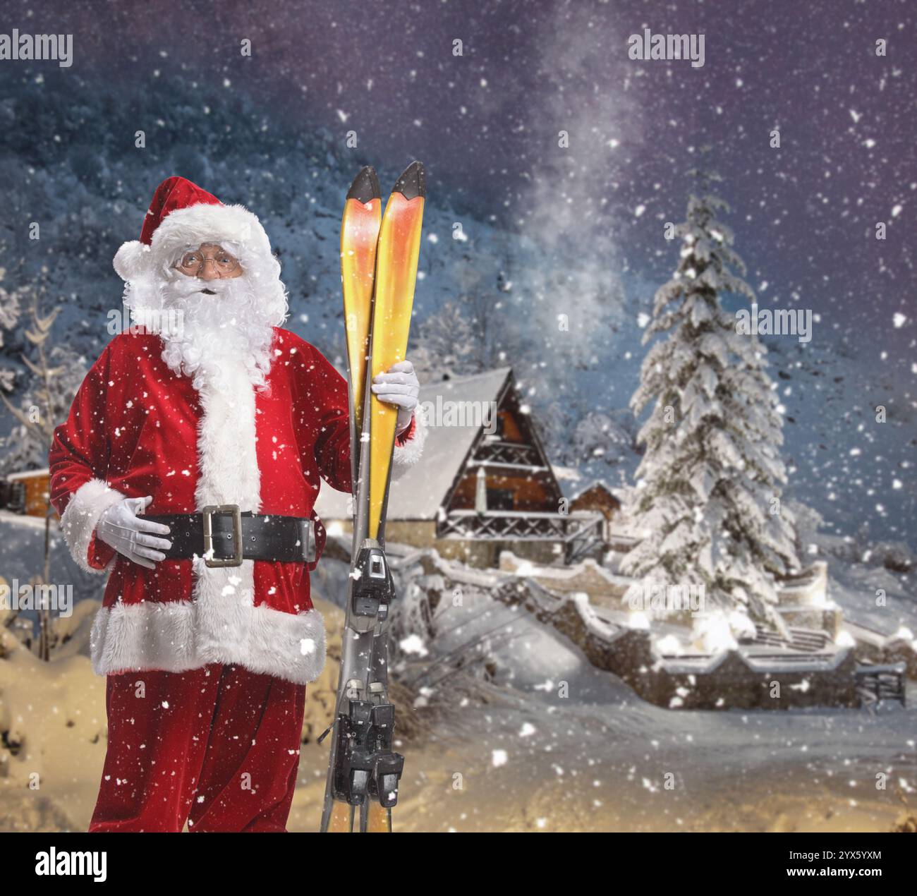 Der Weihnachtsmann hält ein Paar Ski in einer verschneiten Nacht am Berg Stockfoto