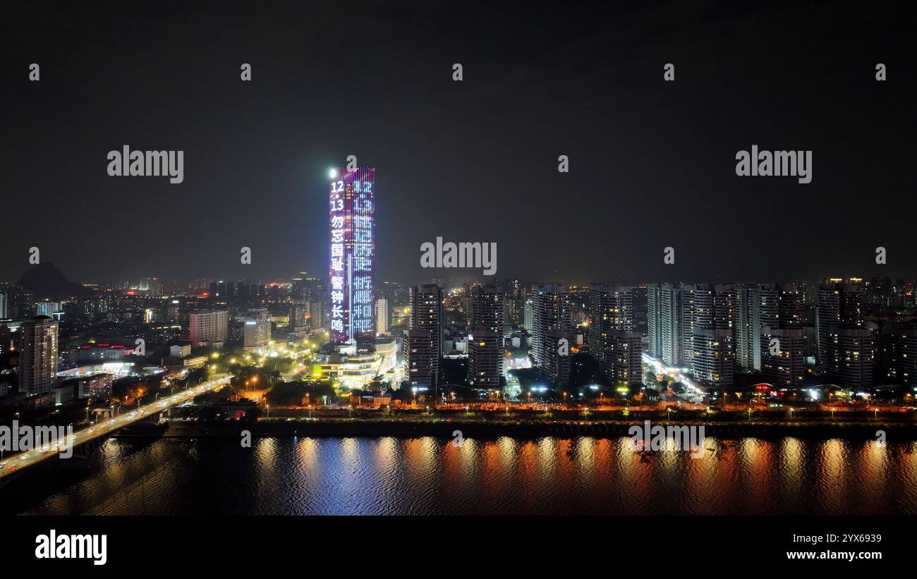 Ein großer LED-Bildschirm an der Außenwand eines Gebäudes rollt Propagandaslogan zum Gedenken an die unschuldigen Opfer des Massakers von Nanjing Stockfoto