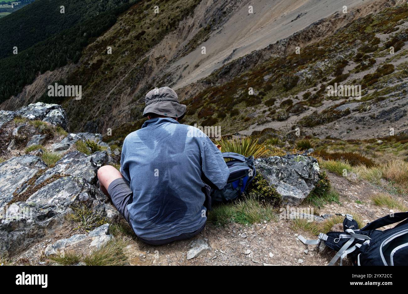 Ein Wanderer hat sich ausgeruht und seinen Rucksack entfernt. Der Rucksack hat seinen Abdruck oder seine Abdrücke auf seinem Shirt in Schweiß hinterlassen. Stockfoto