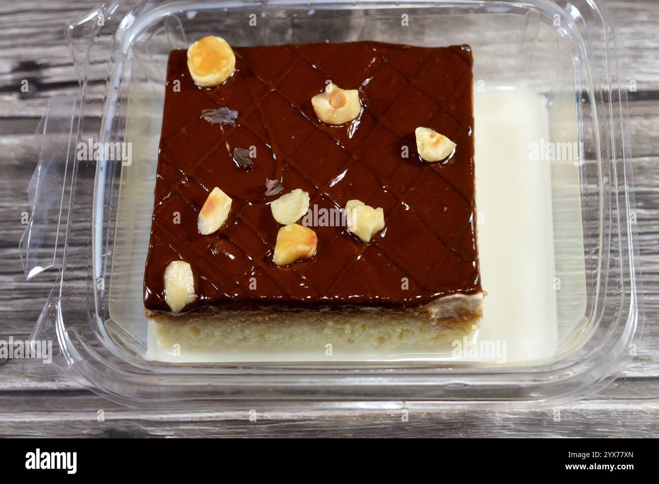 Schokoladenpaste und Haselnussstücke auf dem Tres Liches-Kuchen, der Pfanne Tres Liches, dem Schwammkuchen, der in 3 Arten von Milch eingeweicht ist, verdampft, kondensiert und whol Stockfoto