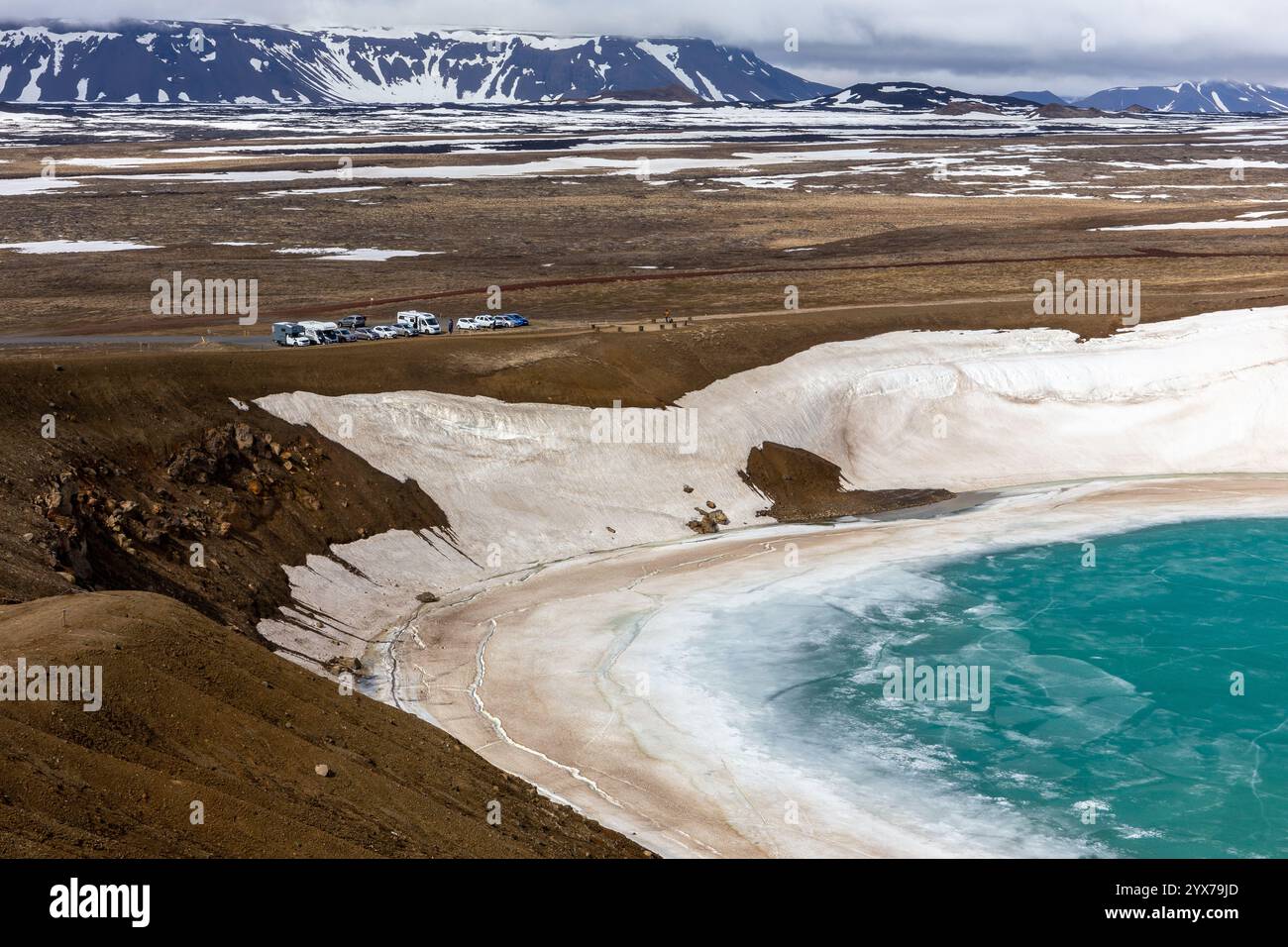 Viti Explosionskrater in Krafla Caldera gefüllt mit türkisfarbenem Wasser, Schnee und Eis, Parkplatz und Bergblick im Hintergrund, Myvatn, Island Stockfoto
