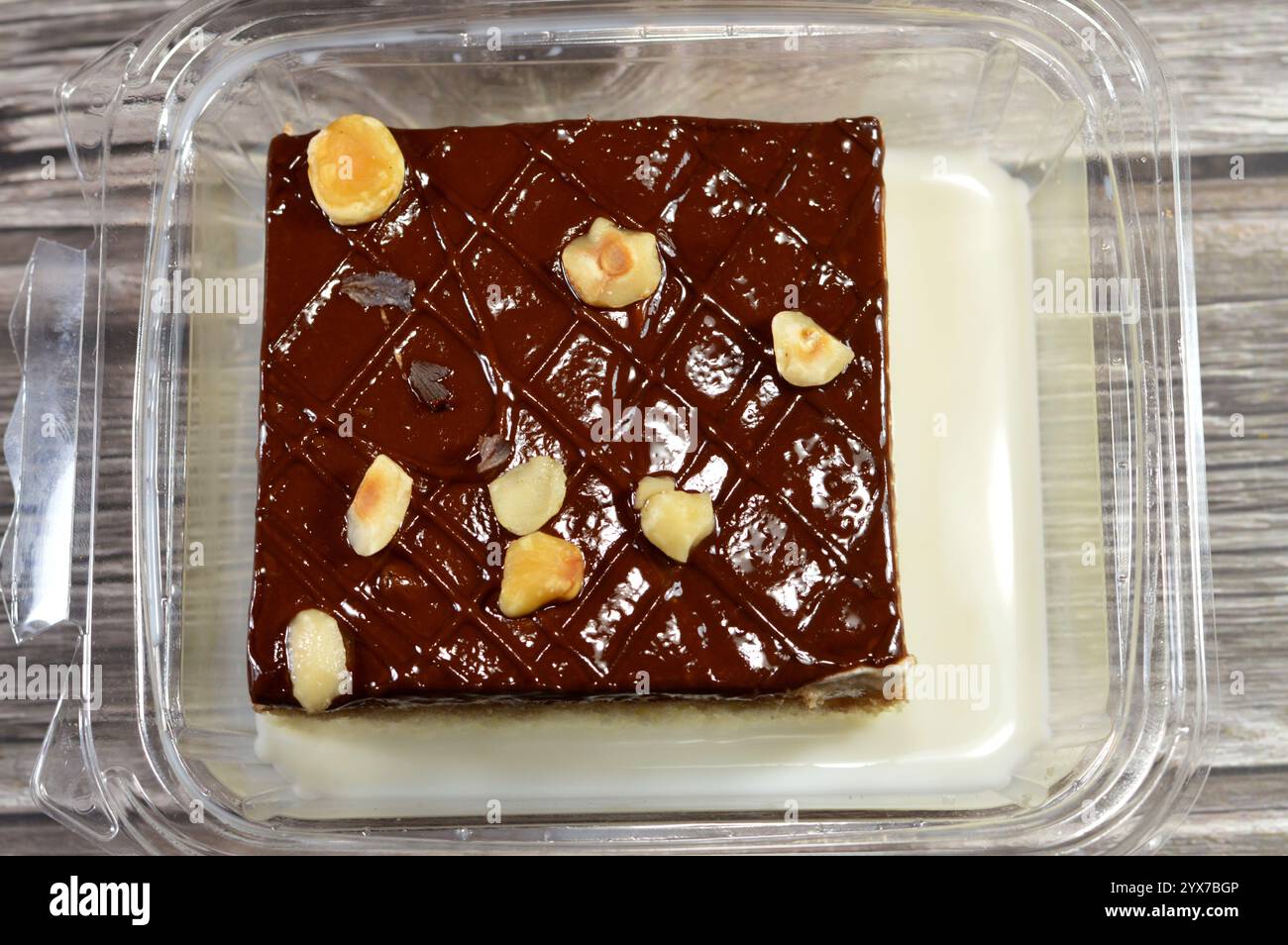 Schokoladenpaste und Haselnussstücke auf dem Tres Liches-Kuchen, der Pfanne Tres Liches, dem Schwammkuchen, der in 3 Arten von Milch eingeweicht ist, verdampft, kondensiert und whol Stockfoto