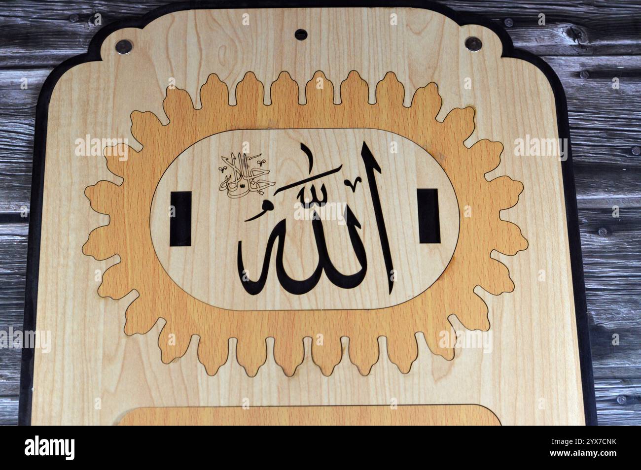 Übersetzung des arabischen Textes (Allah, der Gott, möge seine Majestät verherrlicht werden), auf einem Holz, Teil eines jeden Tages an der Wand hängenden arabischen Kalenders, Allah ist der Stockfoto