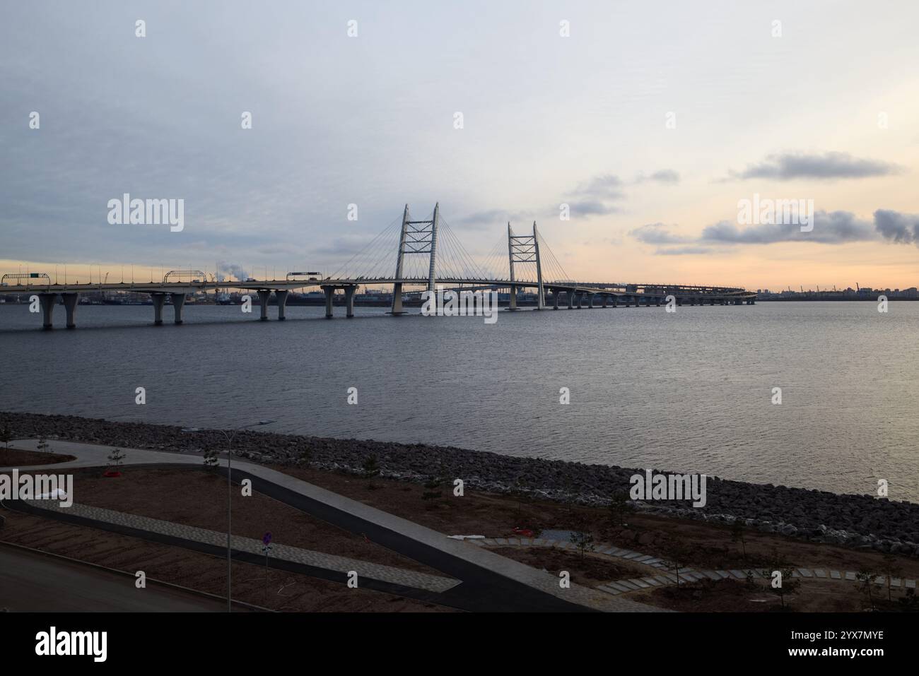 Der atemberaubende Blick auf den Sonnenuntergang einer modernen Hängebrücke zeigt eine urbane Landschaft in der Abenddämmerung Stockfoto