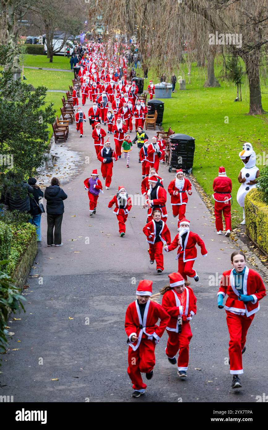 Menschen, die in Santa-Kostümen laufen, Santa-Fun-Rennen oder -Dash, Princes Street Gardens, Edinburgh, Schottland, Großbritannien Stockfoto