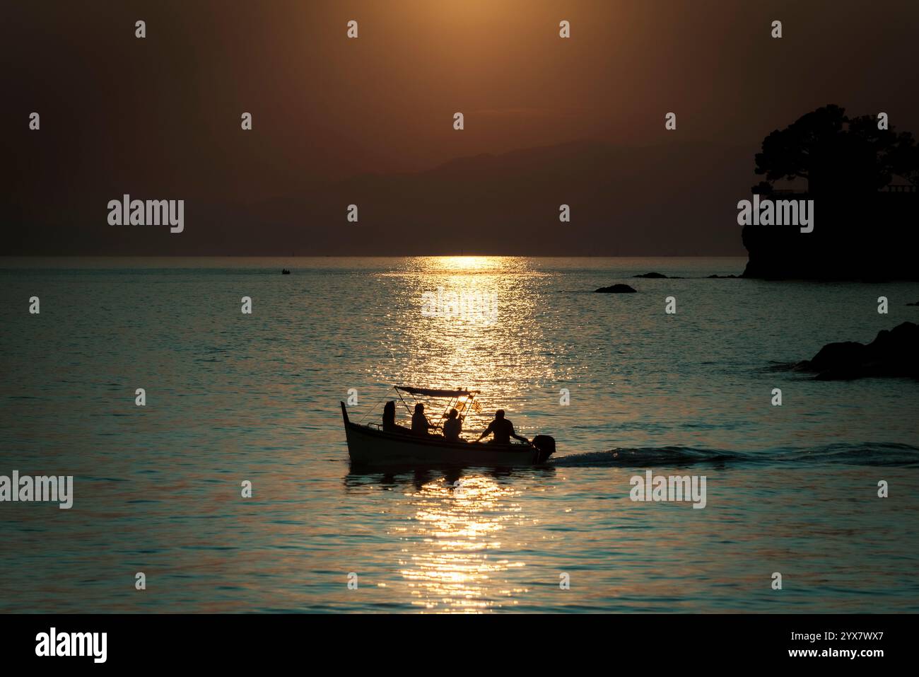 Leute auf einem Boot bei Sonnenuntergang. Stockfoto