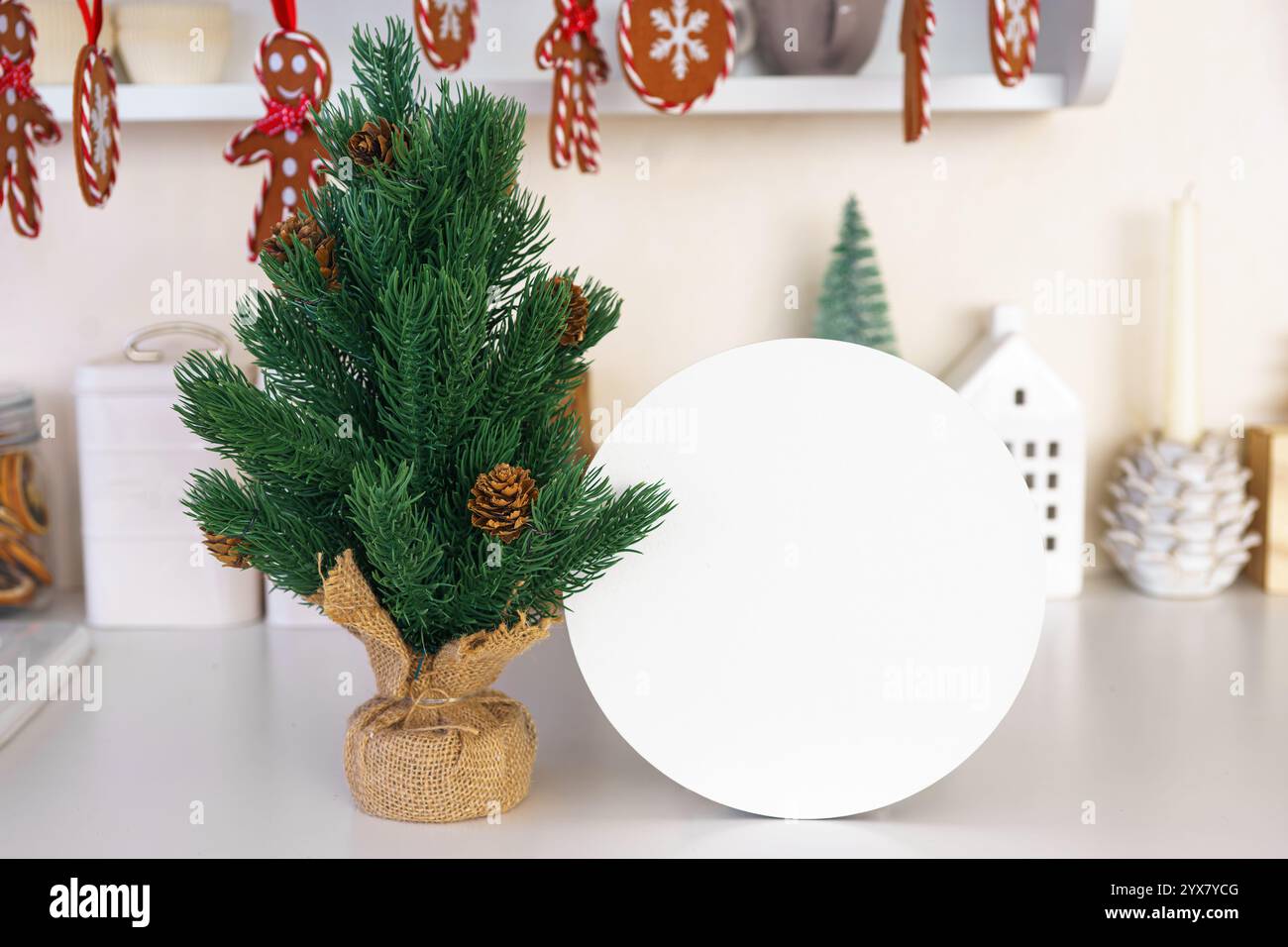 Kleiner Tannenbaum mit Tannenzapfen und weißem Kreis, runde Papierform für Text. Weihnachtsschmuck und -Dekoration, gemütliches festliches Ambiente Stockfoto