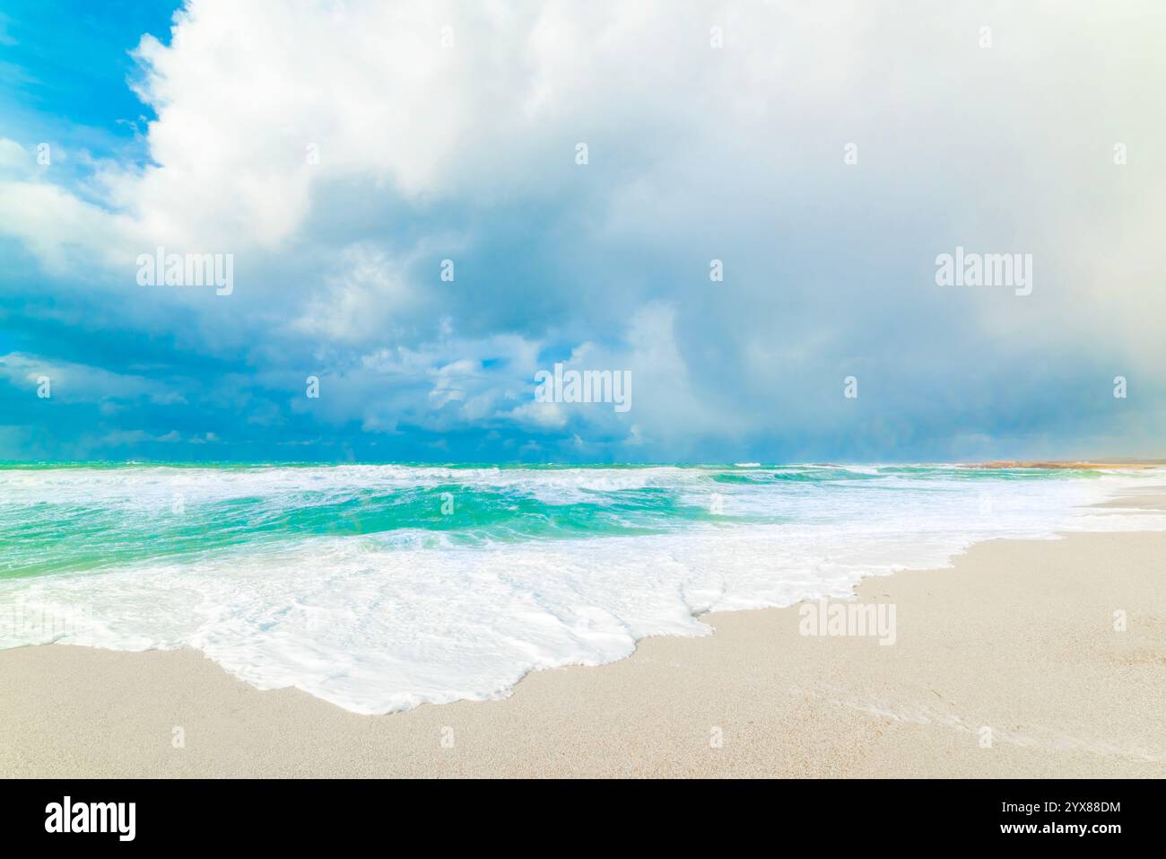 Türkisfarbenes Wasser unter einem blauen Himmel mit riesigen Wolken im Arutas Strand. Sardinien, Italien Stockfoto